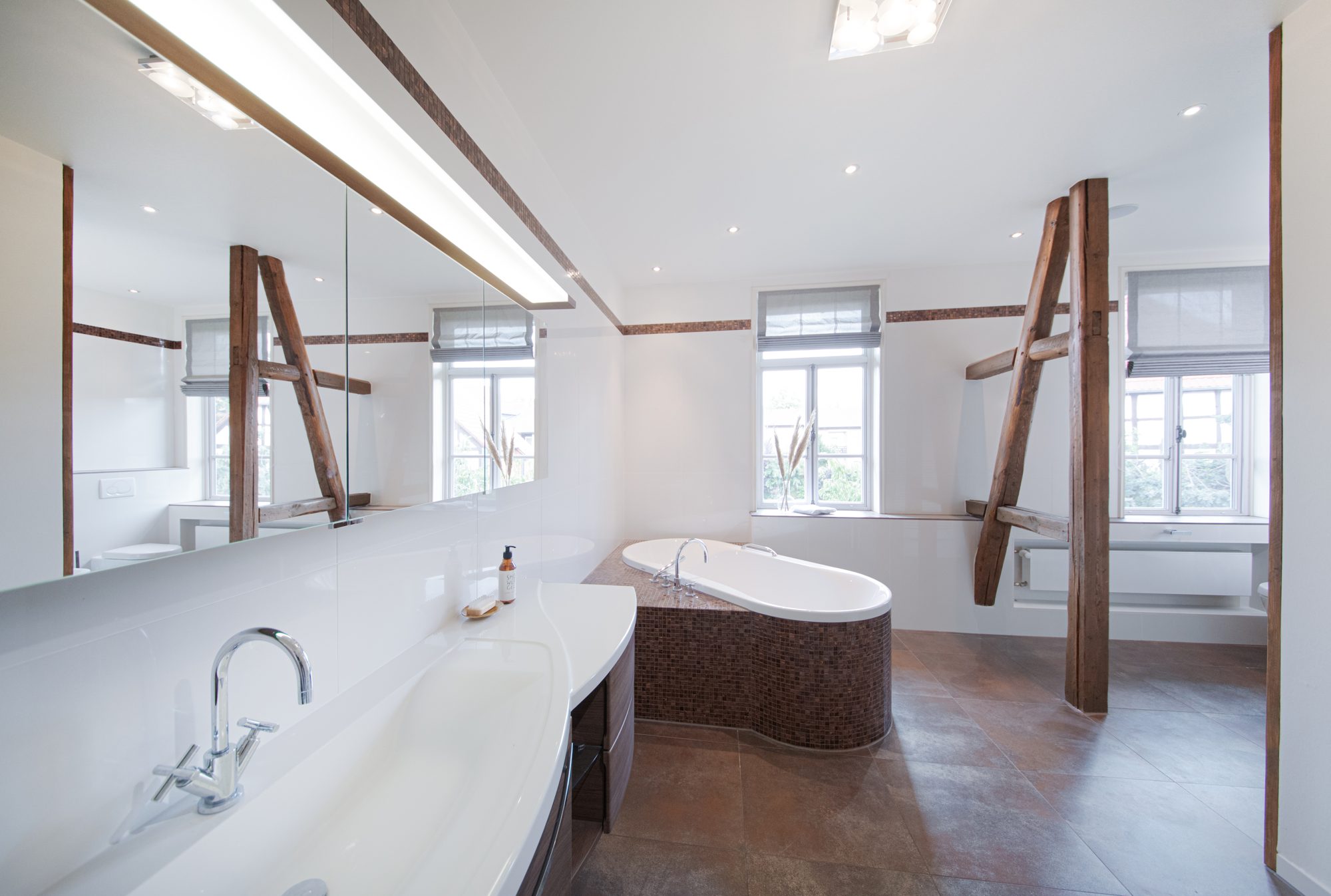 Badezimmer im Herrenhaus mit freistehender Badewanne unter Dachbalken